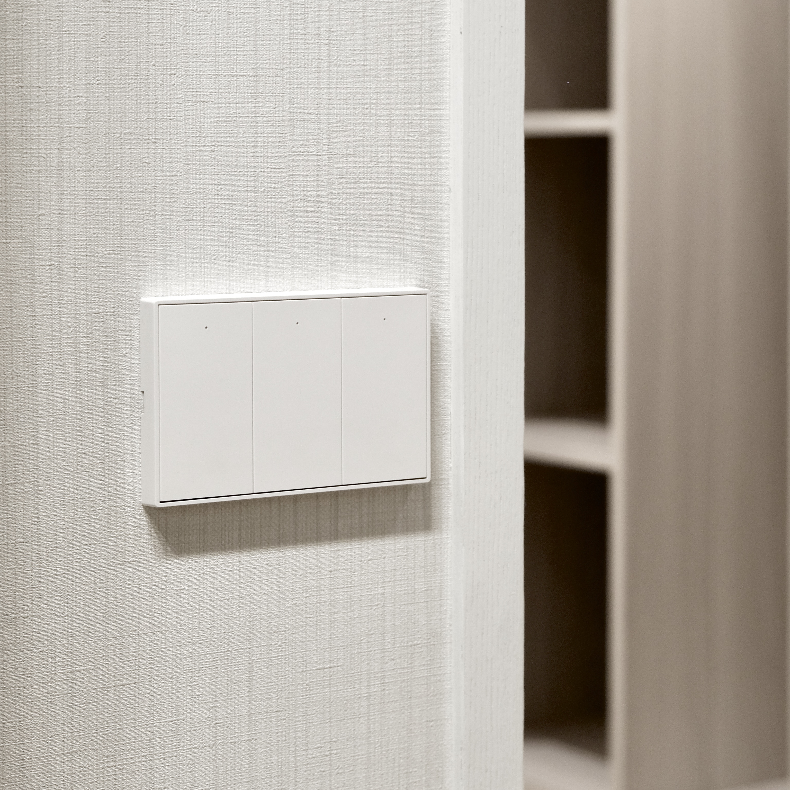 Zemismart K606 三鍵款智慧開關，其簡潔的白色面板完美地融入了臥室富有質感的紋路牆面。